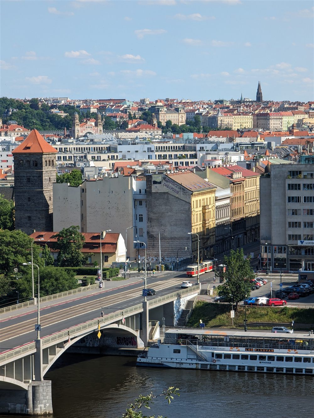 Das Moldauufer in Prag mit Brücke und Tram